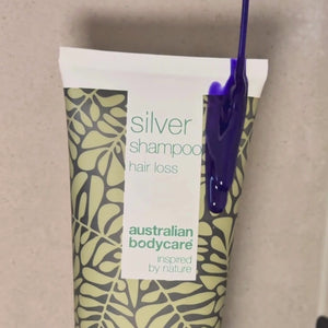 Video waarin te zien is hoe onze Hair Loss Silver Shampoo met zilver-paarse tint wordt aangebracht op nat haar onder de douche.