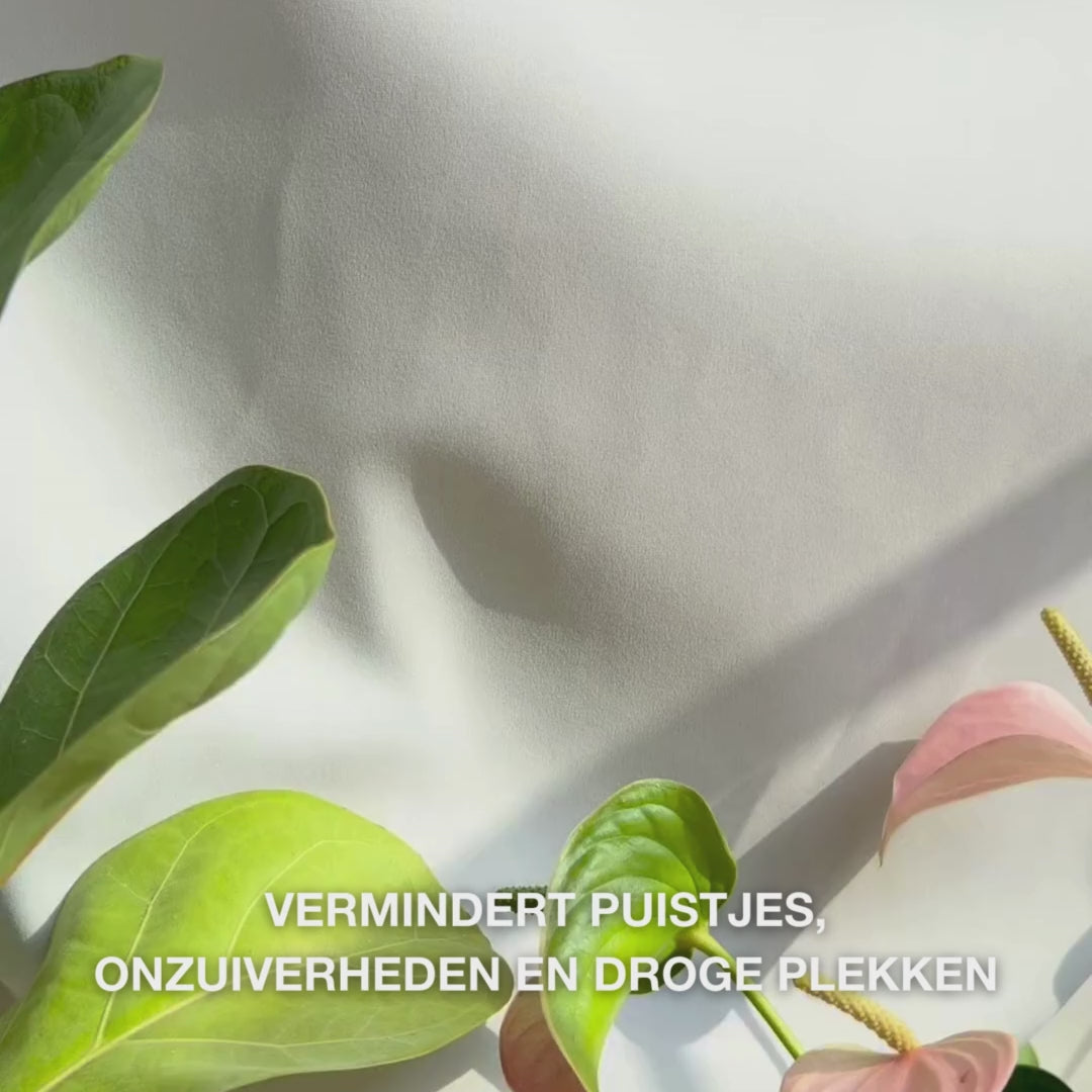Close-up van een hand die een beetje lichte, romige Body Lotion met salicylzuur doseert op de handpalm en deze in ruwe, onzuiverheidsgevoelige huid masseert: de zachte, snel absorberende textuur exfolieert voorzichtig dode huidcellen, hydrateert met hyaluronzuur en melkzuur, en verfijnt de huidstructuur met salicylzuur en niacinamide.