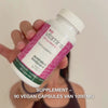 Close-up van een hand die het flesje met Vitamine B12 voedingssupplement vasthoudt, het deksel opent en gladde, witte capsules uitschenkt—het product voor dagelijks gebruik ter ondersteuning van energie, immuunsysteem, zenuwstelsel en vermindering van vermoeidheid.