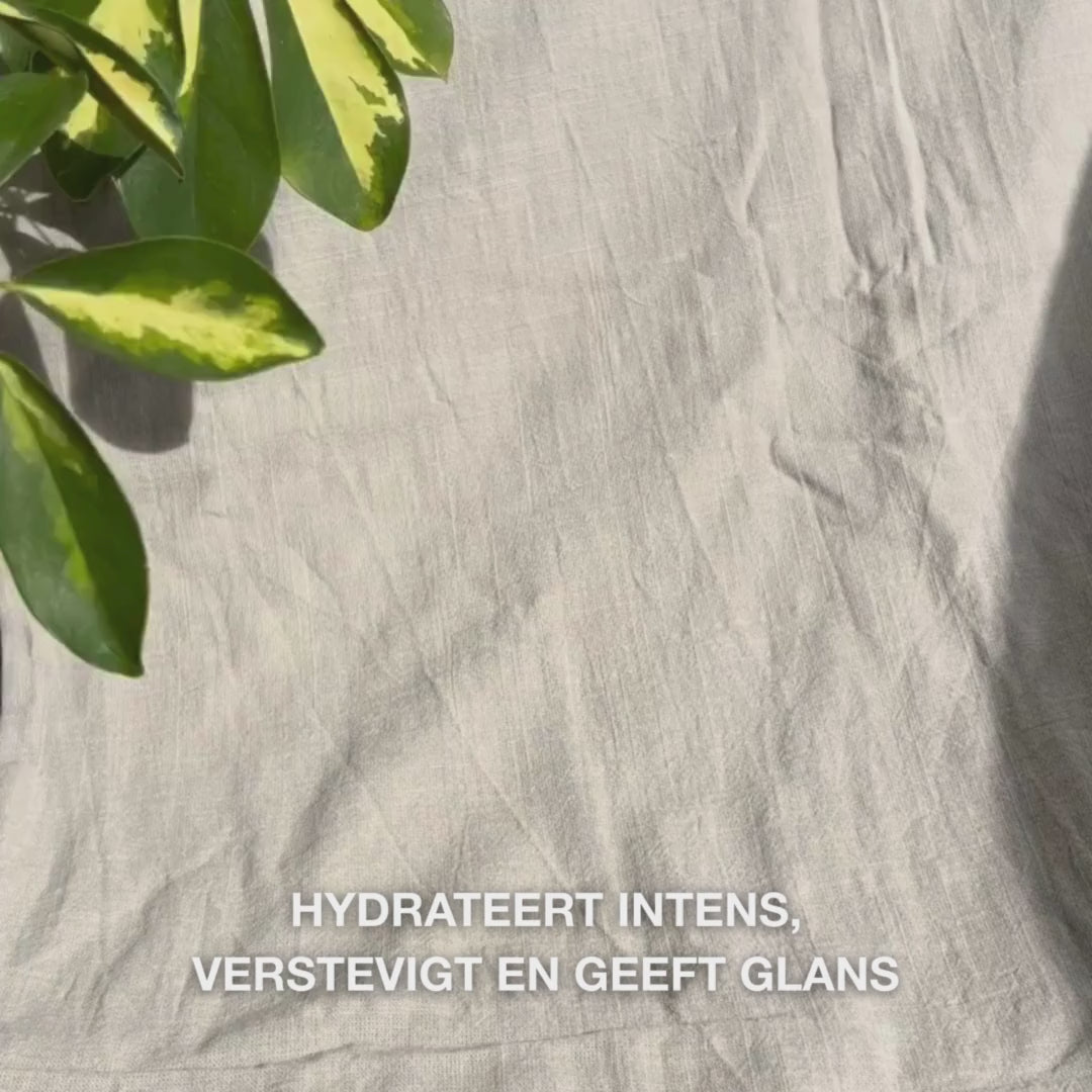 Close-up van een vrouw die een felroze gezichtsmasker met vitamine B12 en collageen op schone huid aanbrengt: ze strijkt het over wangen, voorhoofd en kin, terwijl de collageen- en B12-rijke formule hydrateert, verstevigt, kalmeert en laat stralen.