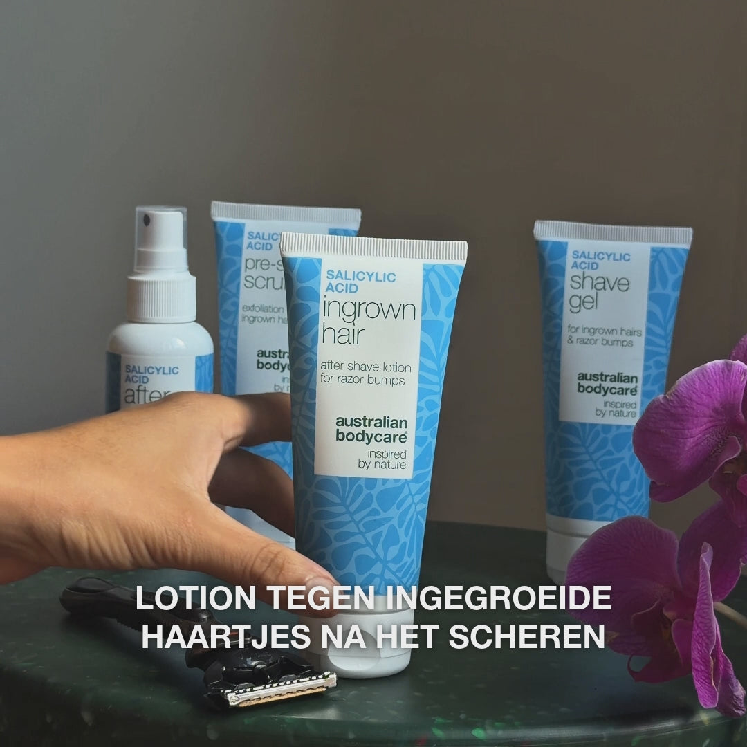 Video: After Shave spray, Pre-shave Scrub, Ingrown Hair lotion en Shave Gel op een tafel naast een scheermes en een orchidee, met de tekst „lotion tegen ingegroeide haartjes na het scheren”. Salicylzuur Aftershave Lotion van Australian Bodycare.
